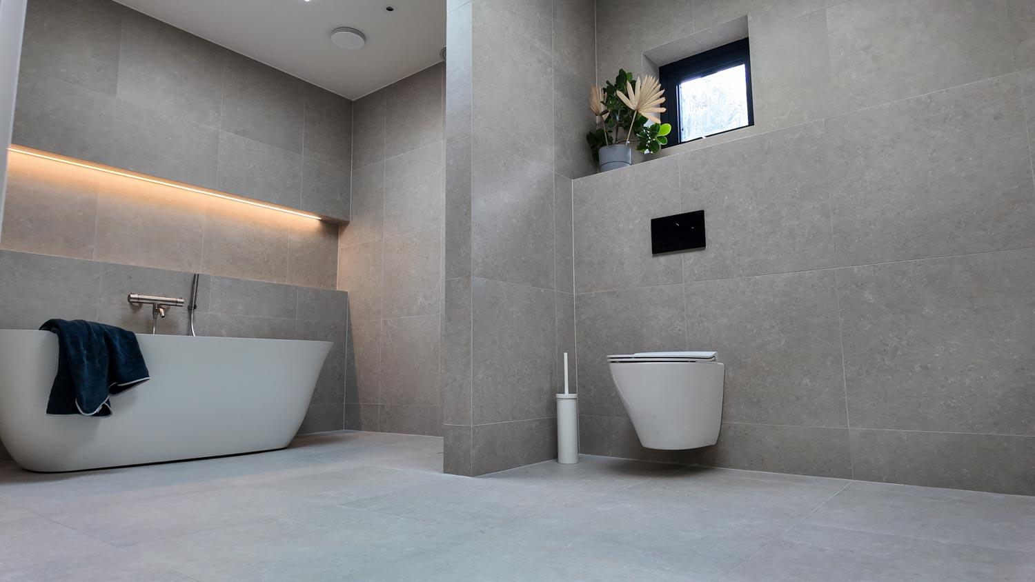 Exklusiv badrumsrenovering i Kalmar med inbyggt badkar och modern belysning utförd av Gus Mur & Kakel.